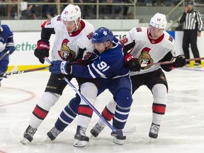 Toronto's John Tavares is checked by Ottawa's Logan Brown and Ryan Dzingel during the second period of the NHL pre-season game between the Maple Leafs and the Senators in Lucan, Ontario, Tuesday, September 18, 2018.