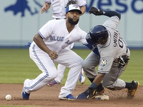 Tampa Bay Rays outfielder Mallex Smith is safe at second base as Toronto Blue Jays Richard Urena drops the ball in Toronto on Tuesday, September 4, 2018. (THE CANADIAN PRESS/Fred Thornhill)