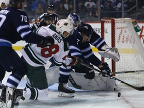 Jets defenceman Ben Chiarot (right) clears a loose puck from the crease against the Minnesota Wild during NHL preseason action at Bell MTS Place last night. Winnipeg won 2-1. Kevin King/Winnipeg Sun