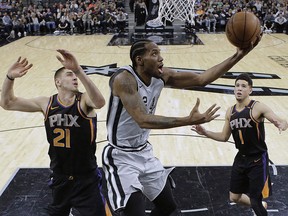 Kawhi Leonard (2), then with San Antonio, scores as Phoenix Suns centre Alex Len (21) and guard Devin Booker (1) defend in San Antonio, Friday, Jan. 5, 2018. (THE CANADIAN PRESS/AP-Eric Gay)