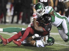Jeff Knox Jr. (top) drags down Ottawa Redblacks running back William Powell during his time with the Saskatchewan Roughriders. The Argos announced the signing of Knox on Thursday and he would be ready to play on Saturday. (CP FILE)