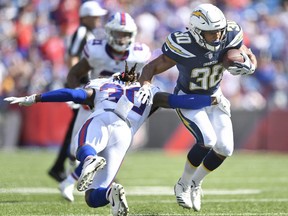 Chargers' Austin Ekeler, right, evades a tackle by Bills' Lafayette Pitts during NFL action in Orchard Park, N.Y., Sunday, Sept. 16, 2018.