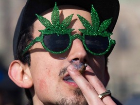 In this April 20, 2018 file photo, a man smokes marijuana during the annual 4/20 rally on Parliament Hill in Ottawa.