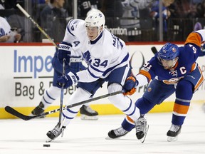 Leafs' Auston Matthews (left) is checked by then-Islanders captain John Tavares in a 2017 game. The two are now teammates in Toronto. AP FILE