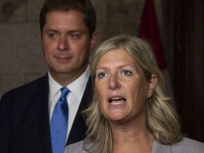 Leader of the Opposition Andrew Scheer looks on as MP Leona Alleslev, who crossed the floor from the Liberal party to Conservative party before Question Period speaks with the media in the Foyer of the House of Commons on Parliament Hill in Ottawa, Monday September 17, 2018.