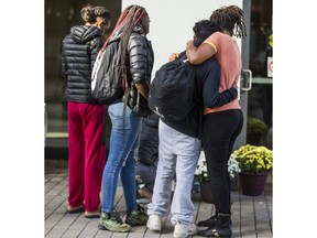 People embrace at a makeshift memorial for TorontoÕs 81st homicide victim of 2018 - Mackai Bishop Jackson - in front of 230 Sackville Street in Regent Park in Toronto, Ont. on Wednesday September 26, 2018. Ernest Doroszuk/Toronto Sun/Postmedia