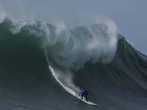 In this Friday, Feb. 12, 2016 file photo Travis Payne rides a giant wave during the finals of the Mavericks surfing contest in Half Moon Bay, Calif. California  (AP Photo/Ben Margot)