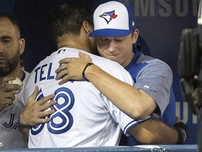 Blue Jays prospect Rowdy Tellez gets a hug in the dugout from teammate Ryan Borucki after he doubled in his first at bat against the Tampa Bay Rays in Toronto on Wednesday, September 5, 2018. (THE CANADIAN PRESS/Fred Thornhill)