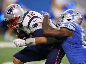 Patriots quarterback Tom Brady, left, is sacked in the fourth quarter by Eli Harold of the Lions at Ford Field in Detroit on Sunday, Sept. 23, 2018.