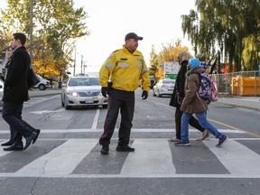 Toronto Police Officer Eddie O'Toole performs crossing guard duties at Queens Quay and Erieann Quay in Toronto on October 26, 2016. (Dave Thomas/Toronto Sun)