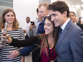 Prime Minister Justin Trudeau stops for a photo following a meeting with a group of businessmen in Longueuil, Que. on Tuesday, August 28, 2018. (THE CANADIAN PRESS/Paul Chiasson)