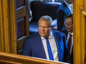 Ontario Premier Doug Ford peers into the legislature during Wednesday morning's session at Queen's Park.