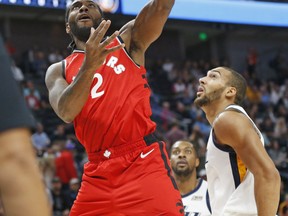 Raptors forward Kawhi Leonard lays the ball in as Utah Jazz centre Rudy Gobert looks on during Tuesday night’s pre-season game. (AP Photo)