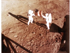 In this NASA handout file photo taken on July 20, 1969, U.S. astronauts Neil Armstrong and "Buzz" Aldrin deploy the U.S. flag on the lunar surface during the Apollo 11 lunar landing mission.