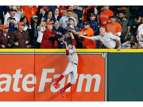 A fan interferes with Mookie Betts of the Boston Red Sox as he attempts to catch a ball hit by Jose Altuve of the Houston Astros (not pictured) in the first inning during Game 4 of the ALCS at Minute Maid Park on October 17, 2018 in Houston, Texas.