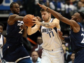 Luka Doncic #77 of the Dallas Mavericks is guarded by Andrew Wiggins #22 and Josh Okogie #20 of the Minnesota Timberwolves at American Airlines Center on October 20, 2018 in Dallas. (Photo by Ronald Martinez/Getty Images)