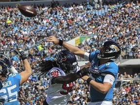 Blake Bortles #5 of the Jacksonville Jaguars tosses the ball away while being pressured by Jadeveon Clowney #90 of the Houston Texans during the second half at TIAA Bank Field on October 21, 2018 in Jacksonville, Florida.