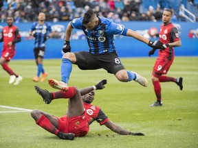 Montreal Impact's Saphir Taider leaps over Toronto FC's Chris Mavinga during  Sunday's game. (THE CANADIAN PRESS)