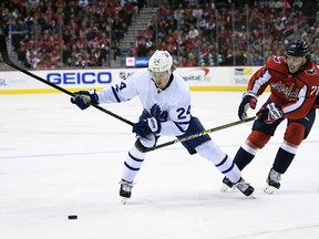 Toronto Maple Leafs right wing Kasperi Kapanen, left,  chases the puck against Washington Capitals right wing T.J. Oshie during the first period of an NHL game, Saturday, Oct. 13, 2018, in Washington. (AP Photo/Nick Wass)