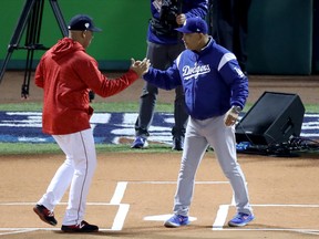Boston Red Sox manager Alex Cora (left) and Los Angeles Dodgers manager Dave Roberts shake hands prior to Game 1 of the World Series on Tuesday night. (GETTY IMAGES)
