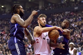 Raptors centre Jonas Valanciunas is fouled by Dallas Mavericks forward Harrison Barnes (right) on his way to the hoop during Friday’s game. (THE CANADIAN PRESS)