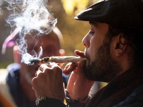 A man smokes a marijuana cigarette during a legalization party at Trinity Bellwoods Park in Toronto, Ontario, October 17, 2018. –