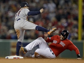 Astros second baseman Jose Altuve (left) forces Red Sox’s J.D. Martinez out after Xander Bogaerts hit into a double play during Game 1 of their American League Championship Series in Boston last night. (AP Photo/Charles Krupa)