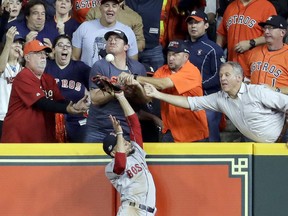 Fans interfere with Boston Red Sox right fielder Mookie Betts trying to catch a ball hit by Houston Astros' Jose Altuve during the first inning in Game 4 of a baseball American League Championship Series on Wednesday, Oct. 17, 2018, in Houston. Altuve was called out.
