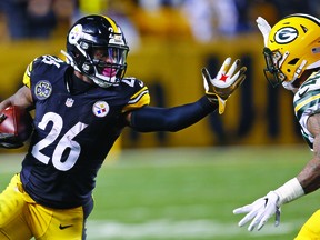 Pittsburgh Steelers running back Le'Veon Bell (26) stiff-arms Green Bay Packers strong safety Morgan Burnett (42) during the first half of an NFL football game in Pittsburgh. (AP Photo/Keith Srakocic