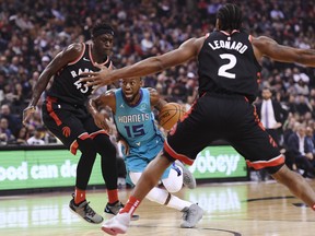 Charlotte Hornets guard Kemba Walker (15) drives between Toronto Raptors forward Pascal Siakam (43) and Raptors forward Kawhi Leonard (2) during first half NBA basketball action in Toronto on Monday, October 22, 2018. THE CANADIAN PRESS/Nathan Denette ORG XMIT: NSD504