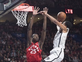 Raptors' Chris Boucher (left) goes up to defend againt the Nets' Spencer Dinwiddie in Montreal. (THE CANADIAN PRESS/Graham Hughes)