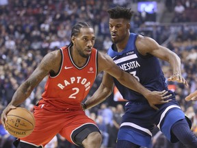 Raptors’ Kawhi Leonard (left) drives past Timberwolves’ Jimmy Butler at Scotiabank Arena on Wednesday.  VERONICA HENRI/TORONTO SUN