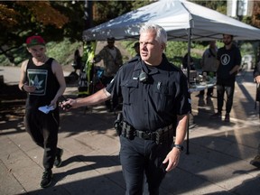 A police officer walks away after stopping to talk to an unauthorized vendor selling cannabis products on the day recreational use of cannabis became legal, in Vancouver, on Wednesday October 17, 2018. (THE CANADIAN PRESS/Darryl Dyck)