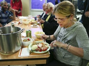 Sandra Seymour, 59, of Toronto, enjoys a Thanksgiving dinner at the Scott Mission, on Spadina Ave., on Oct. 8, 2018. (Veronica Henri, Toronto Sun)