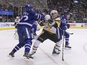 Maple Leafs’ Nikita Zaitsev (left) ties up Pittsburgh Penguins’ Sidney Crosby (centre) as Leafs’ Jake Gardiner works the other side during Thursday night’s game at the Scotiabank Arena. (JACK BOLAND/TORONTO SUN)