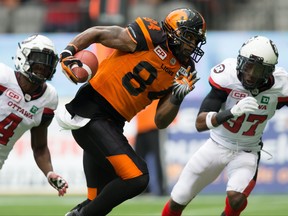 B.C. Lions' Emmanuel Arceneaux, centre, runs the ball in for a touchdown after making a reception as Ottawa Redblacks' Jerrell Gavins, left, and Winston Rose, right, defend during the first half of a CFL football game in Vancouver, on Saturday, October 7, 2017. (THE CANADIAN PRESS/Darryl Dyck)