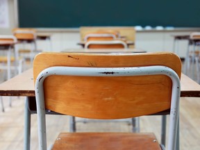 Desks sit in an empty classroom.