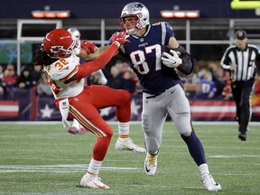 New England Patriots tight end Rob Gronkowski (87) gives a stiff arm to Kansas City Chiefs free safety Ron Parker (38) after catching a pass Sunday, Oct. 14, 2018, in Foxborough, Mass. (AP Photo/Steven Senne)