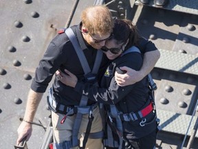 Big-hearted Prince Harry gives a hug to Australian war widow Gwen Cherne. He brushed off his handlers when they wanted him to move along.