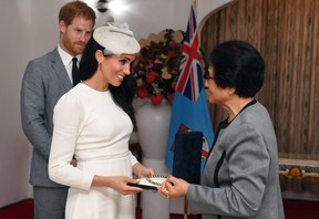Meghan is presented with a pearl necklace from Sarote Faga Konrote as Prince Harry looks on during the first day off their tour to Fiji. GETTY IMAGES