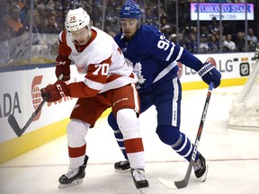 Toronto Maple Leafs' Igor Ozhiganov, right, fights for the puck against the Detroit Red Wings' Christoffer Ehn during the first period of their NHL pre-season hockey game Friday September 28, 2018 in Toronto. THE CANADIAN PRESS/Jon Blacker