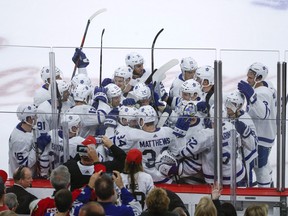 Maple Leafs defenceman Morgan Rielly celebrates with teammates after scoring in overtime to beat the Blackhawks in Chicago — the first road game of the season for the team and its ‘ultimate fan,’ Mike Wilson.  Kamil Krzaczynski/AP