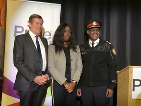 (from left) Mayor John Tory, Pride Toronto executive director Olivia Nuamah and Toronto Police Chief Mark Saunders pose for photos after Pride Toronto announces police will be allowed to apply to march in 2019's parade after a two-year ban, on Oct. 16, 2018.