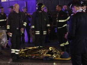 Rescuers evacuate a person who was wounded after an escalator at the "Repubblica" subway station in Rome, started running much too fast before crashing, Tuesday, Oct. 23, 2018.