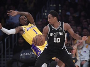 Los Angeles Lakers guard Kentavious Caldwell-Pope, left, falls as San Antonio Spurs guard DeMar DeRozan drives toward the basket during the first half of an NBA basketball game Monday, Oct. 22, 2018, in Los Angeles.