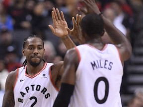 Raptors’ Kawhi Leonard (left) high fives teammate C.J. Miles during Tuesday’s win against the Philadelphia 76ers in Toronto. Leonard has made an immediate impact for the Raps. (CP PHOTO)