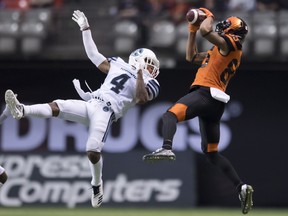 Lions wide receiver Shakeir Ryan hauls in a pass as defensive back Will Likely of the Argos goes up but can’t get to the ball on Saturday night in B.C.                (Jonathan Hayward/CP)