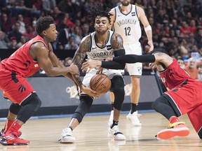 Raptors' Kyle Lowry (left) and Danny Green defend against Brooklyn Nets' D'Angelo Russell during NBA pre-season action in Montreal on Wednesday. (Graham Hughes/The Canadian Press)