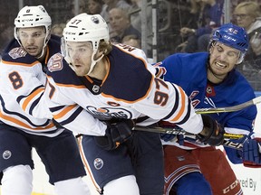 Edmonton Oilers centre Connor McDavid (97) and New York Rangers defenceman Brendan Smith (42) vie for a loose puck Saturday, Oct. 13, 2018, at Madison Square Garden in New York. (AP Photo/Mary Altaffer)