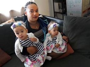 Ebony Menzies, with her twin daughters, is criticizing Metrolinx policy for transporting infants less than 22 lbs.  (Dave Abel/Toronto Sun)